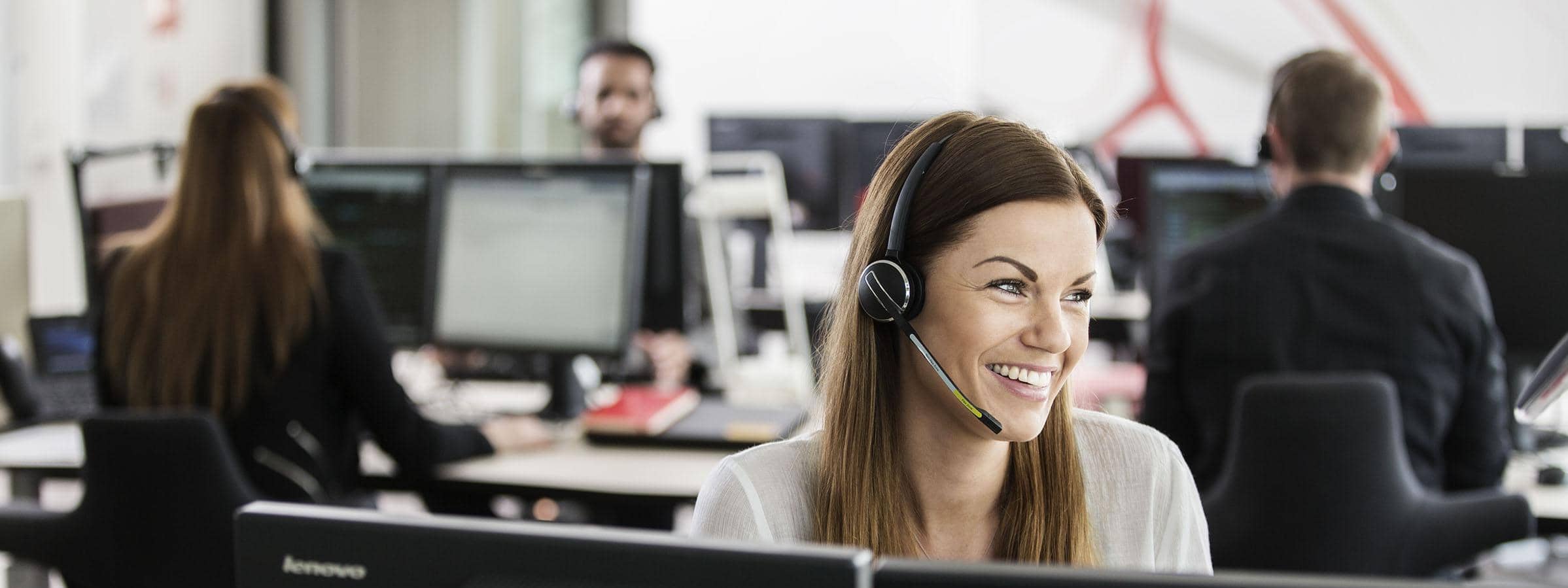 Kvinde der snakker i headset bag to skærme