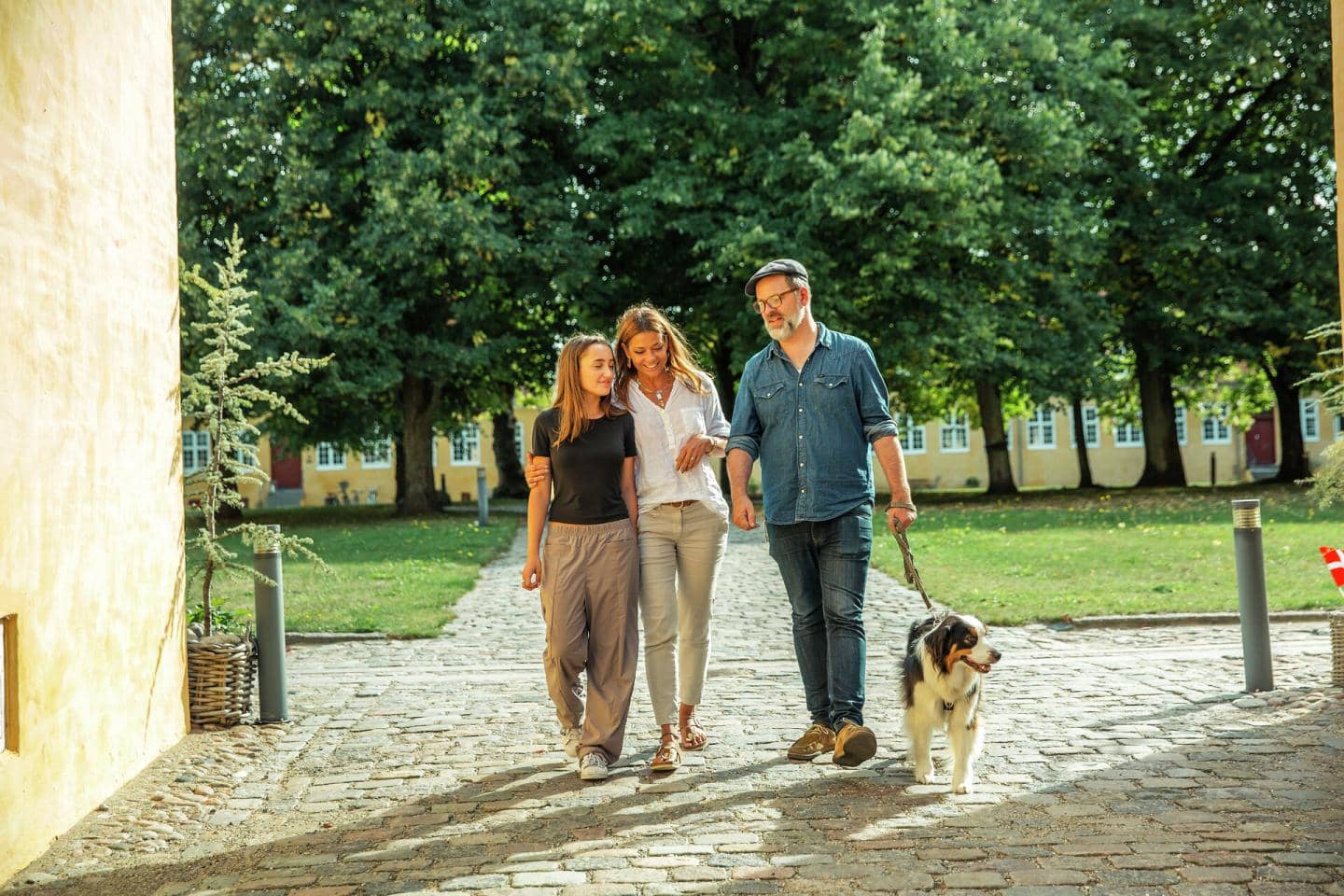 Familie går en tur i en park med deres hund