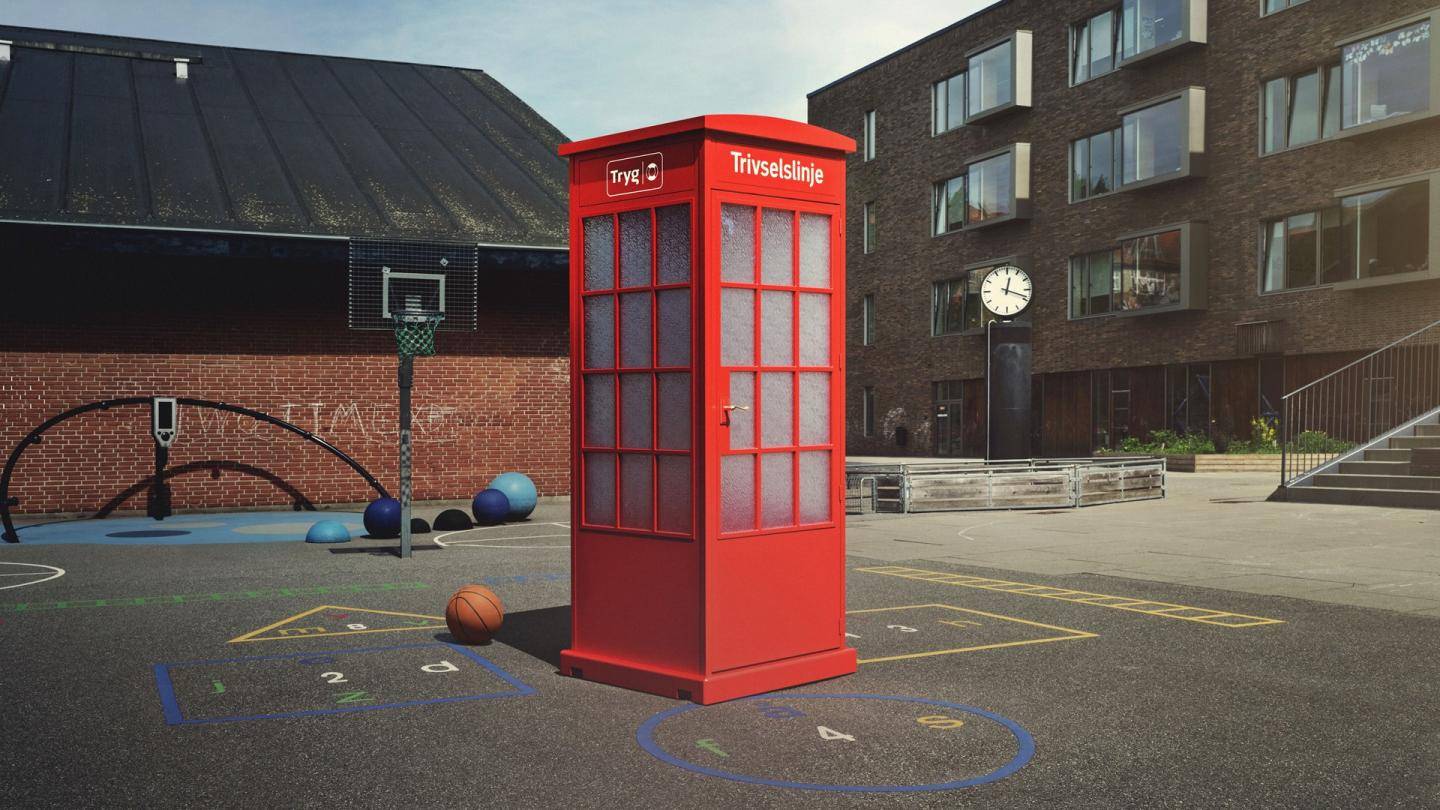Rød telefonboks, der står i en skolegård